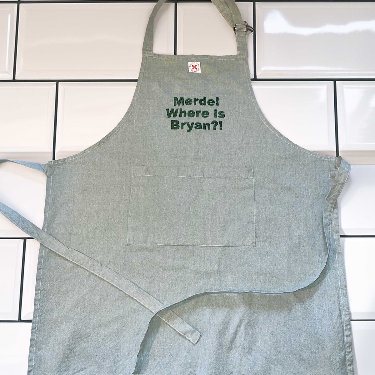 TABLIER DE CUISINE VERT AVEC UNE POCHE CENTRALE, BRODERIE MERDE WHERE IS BRYAN