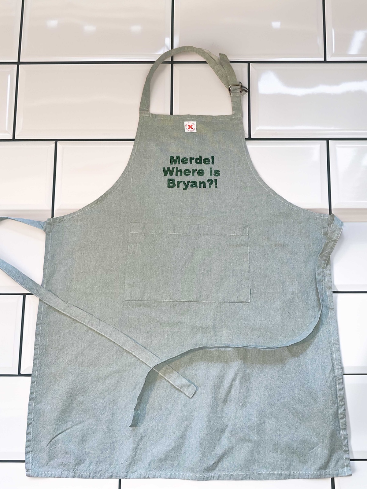 TABLIER DE CUISINE VERT AVEC UNE POCHE CENTRALE, BRODERIE MERDE WHERE IS BRYAN